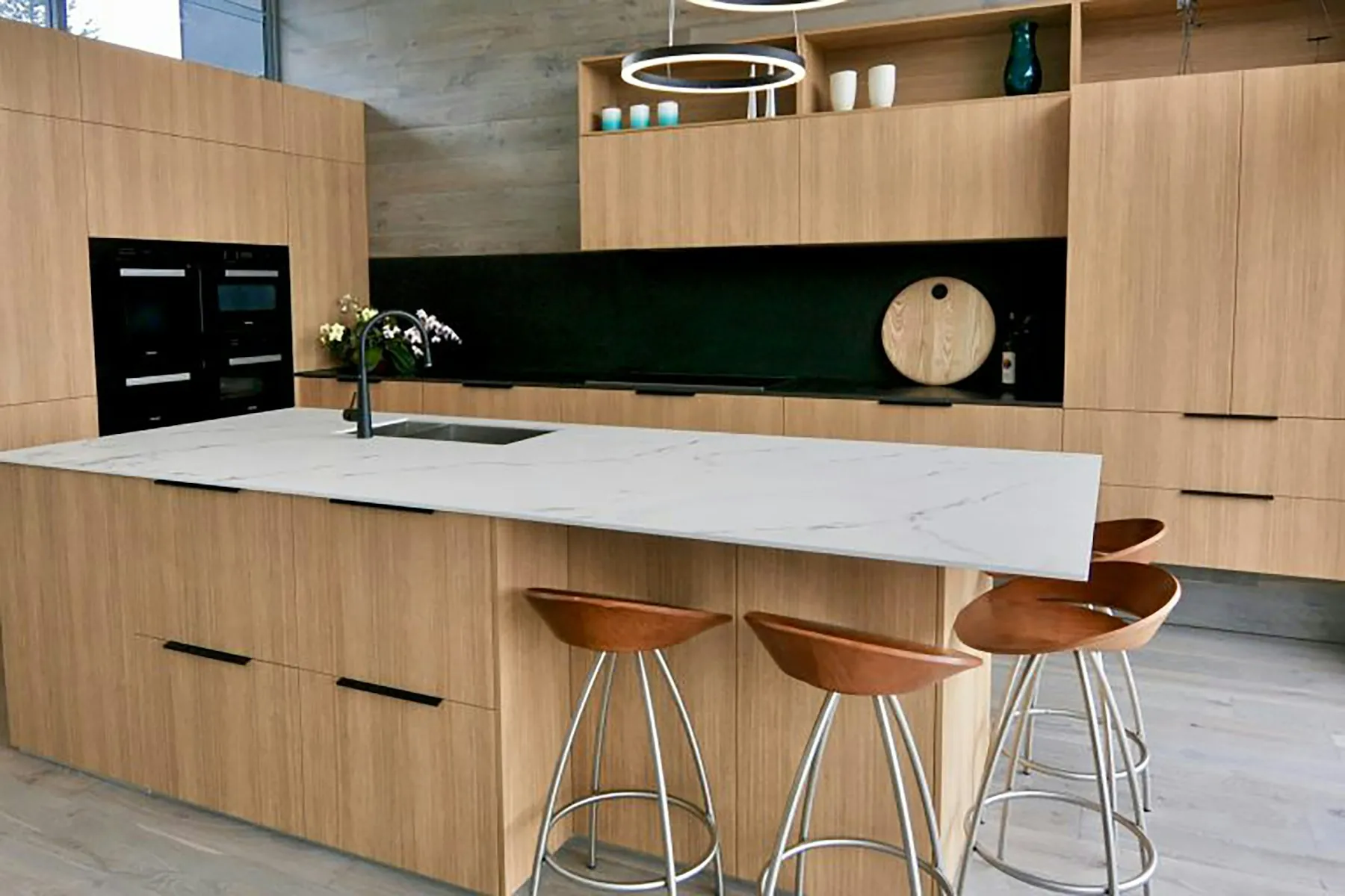 Marble-topped island with a walnut base and copper-toned bar stools.